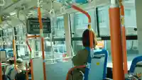 a woman sitting in a brightly lit bus.f7651128