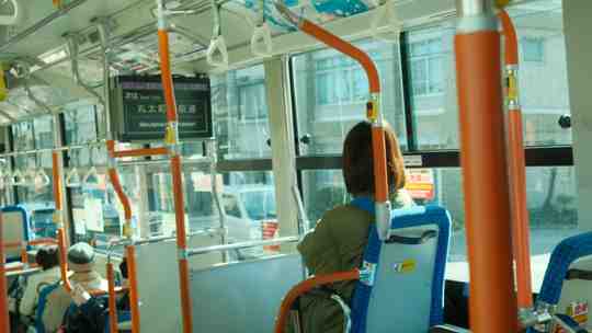 a woman sitting in a brightly lit bus.f7651128