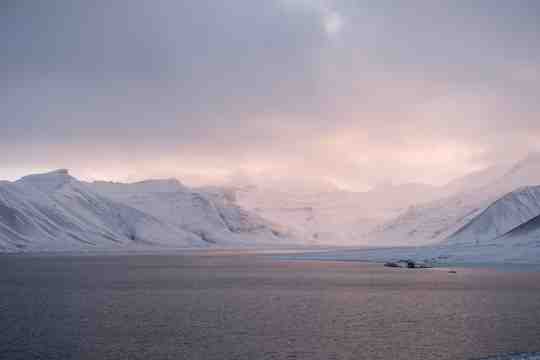 white snowy mountains with a lake in the foreground iceland.17763266