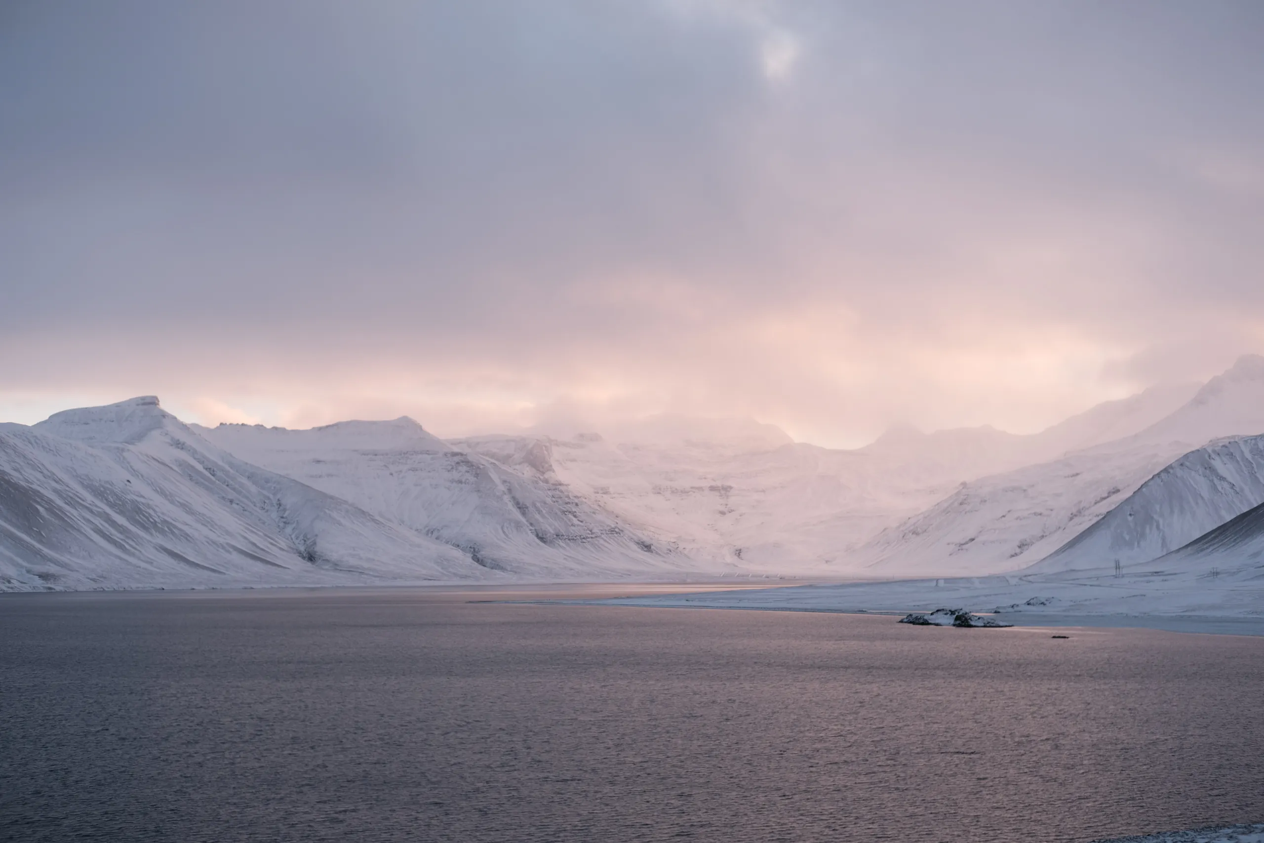 white snowy mountains with a lake in the foreground iceland.17763266